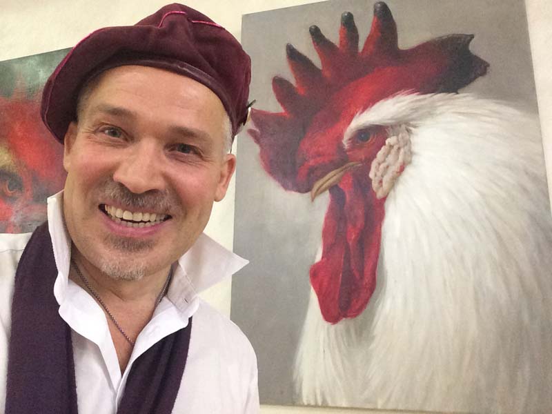 Шаржист Михаил Шабалин рядом с картиной Петуха